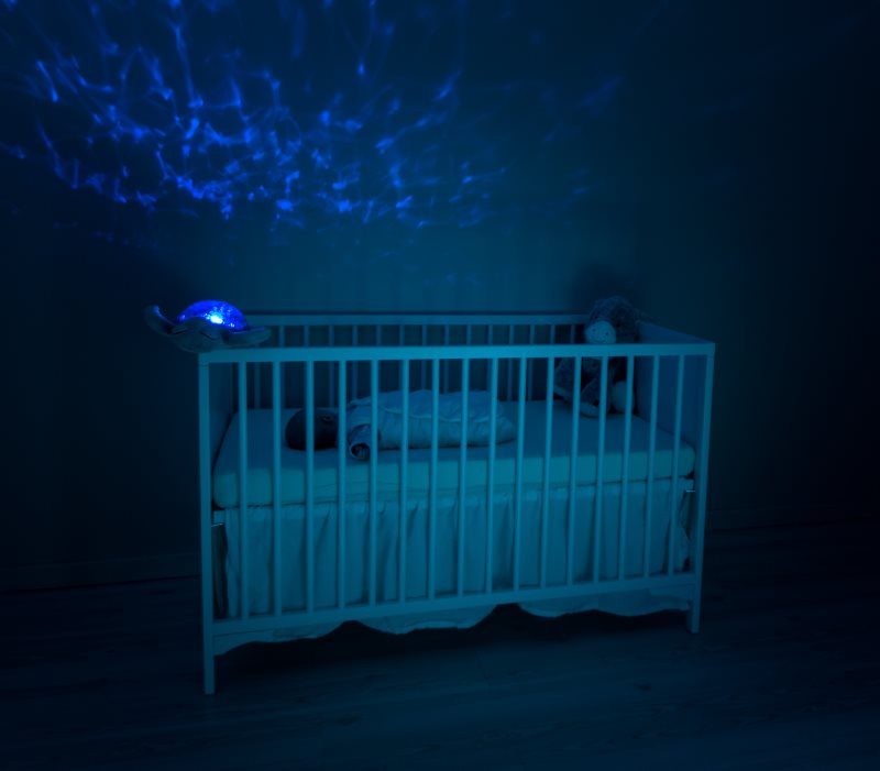 Baby liegt im Bett mit Nachtlicht