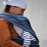 Mama mit Säugling im blauen Tragetuch