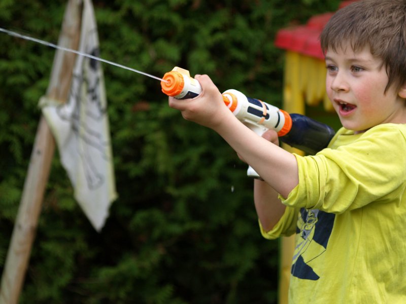 Ein Kind, dass mit einer Wasserpistole spielt.