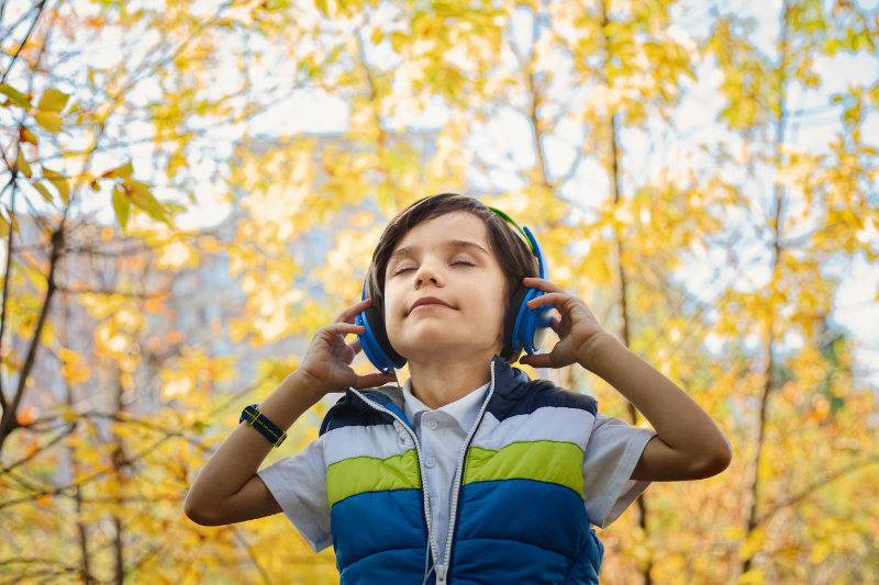 Junge hört mit Kinderkopfhörern Musik