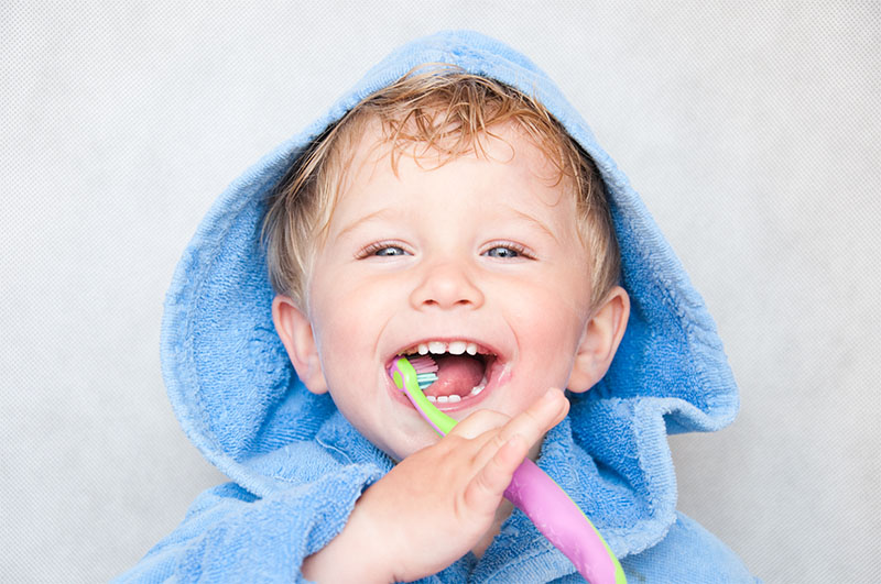 Kind putzt Zähne mit Kinderzahnpasta