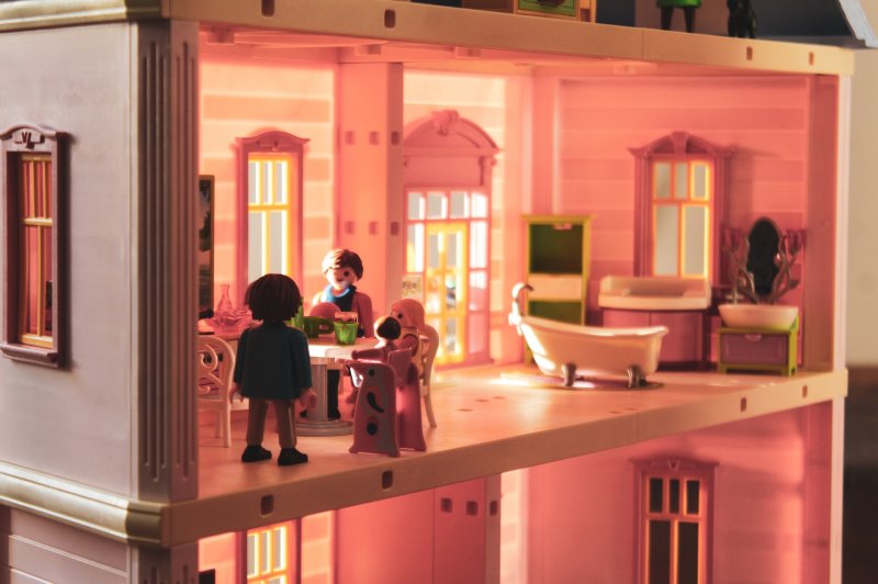 Playmobil-Figuren sind in einem dekorierten Puppenhaus platziert.