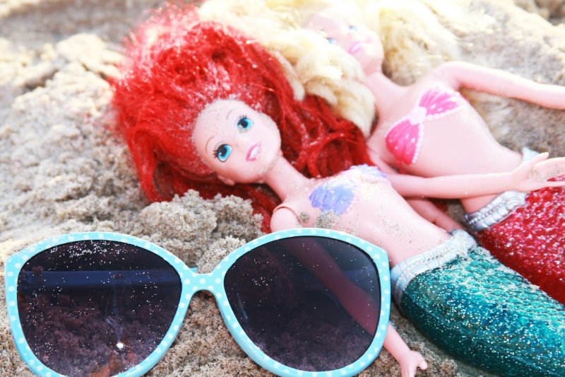 Meerjungfrauen-Puppen liegen im Sand