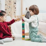 Zwei Kinder die mit Holzspielzeug spielen