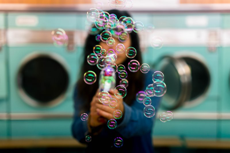 Frau macht Seifenblasen mit einer Seifenblasenpistole
