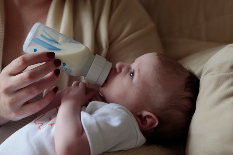 Baby trinkt die Milch aus der Flasche