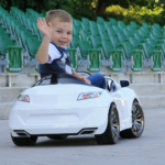 Ein Kind auf einem Kinder-Elektroauto.