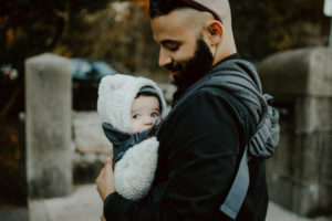 Vater trägt Kind in Babytrage